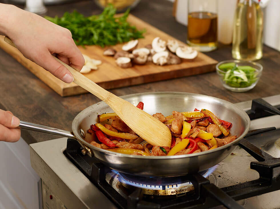 Chicken and bell peppers being sautéed 